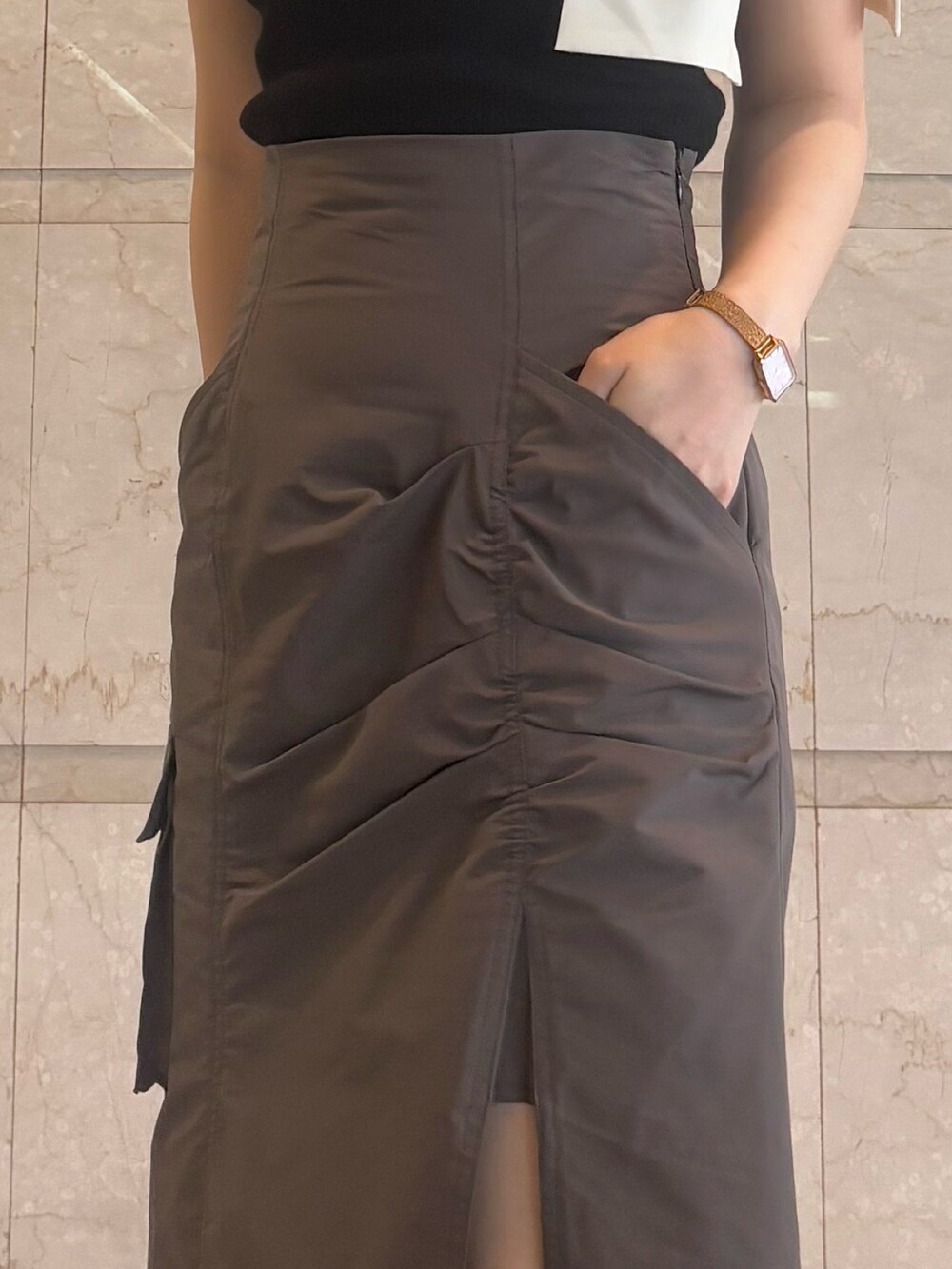 ブラウン系のスカート、ブラウン系のサンダル、ブラック系のニット/セーターを着用したレディースの夏コーディネートの7枚目の写真