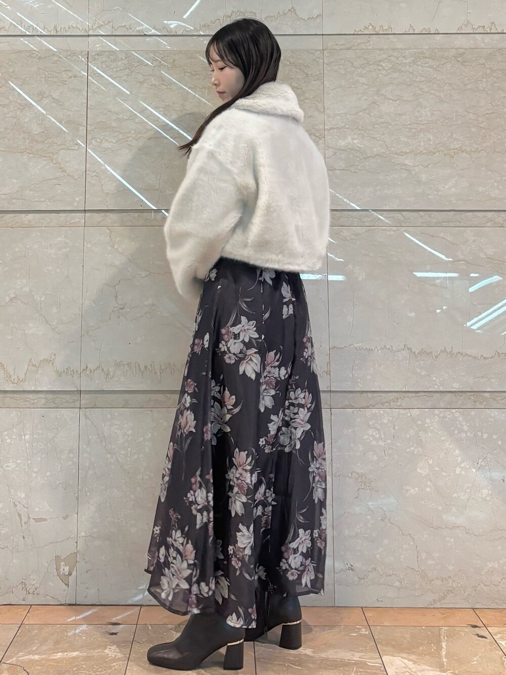 グレー系のワンピース、ブラウン系のブーツ、ホワイト系のその他アウターを着用したレディースの冬コーディネートの3枚目の写真