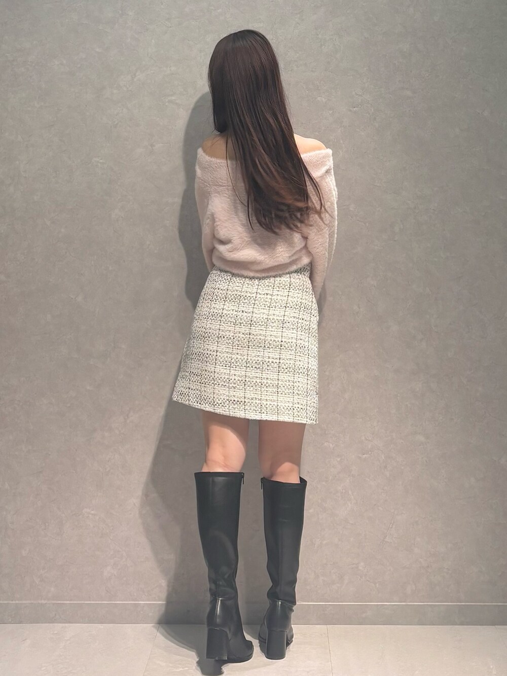 ホワイト系のスカート、ピンク系のニット/セーター、ブラック系のブーツを着用したレディースの秋コーディネートの5枚目の写真