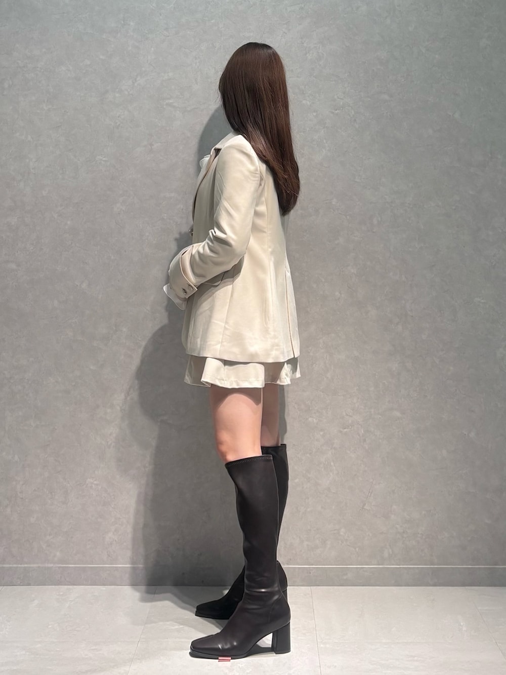 ホワイト系のスカート、ホワイト系のテーラードジャケット、ベージュ系のニット/セーターを着用したレディースの冬コーディネートの4枚目の写真