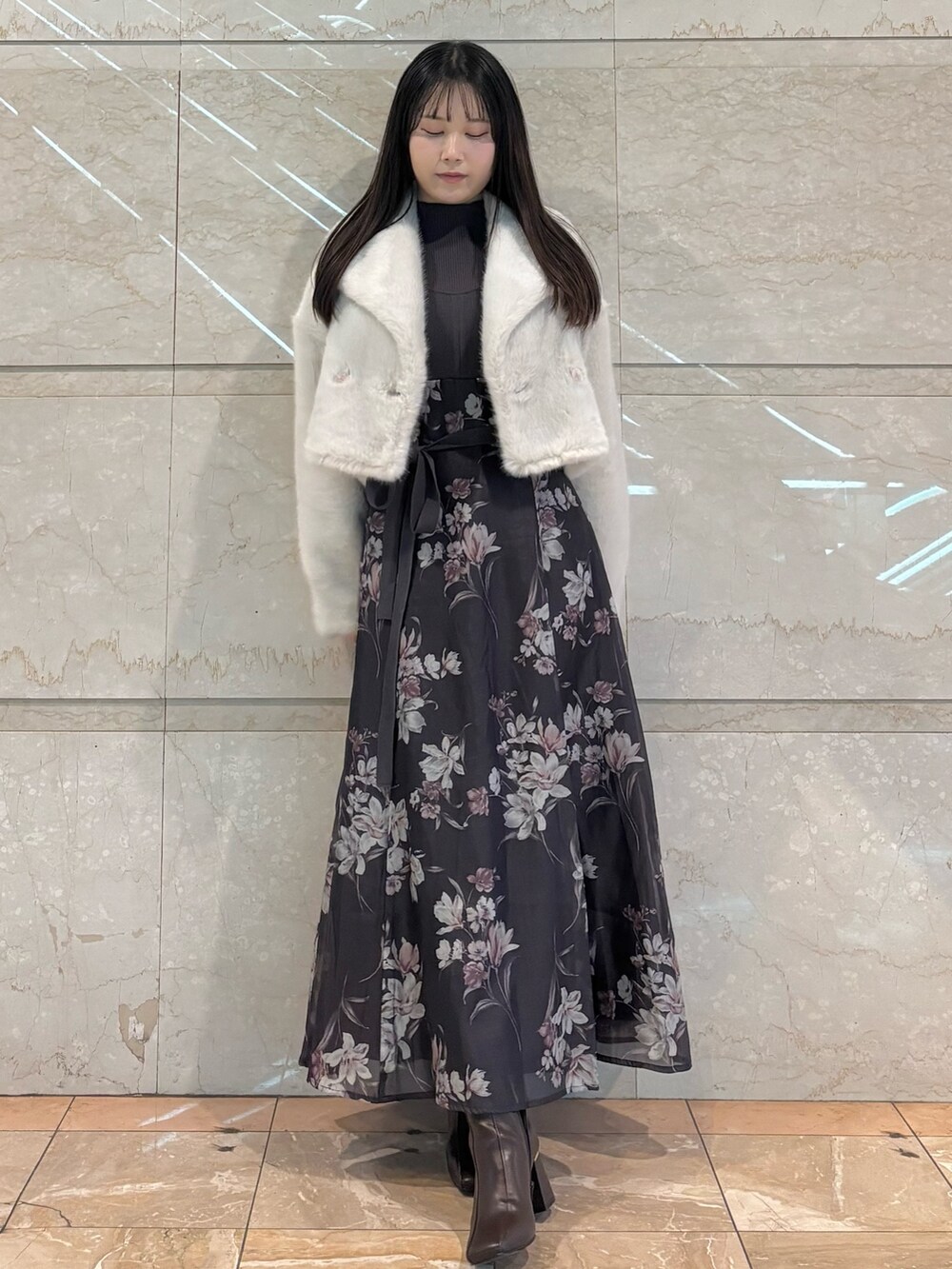 グレー系のワンピース、ブラウン系のブーツ、ホワイト系のその他アウターを着用したレディースの冬コーディネートの2枚目の写真