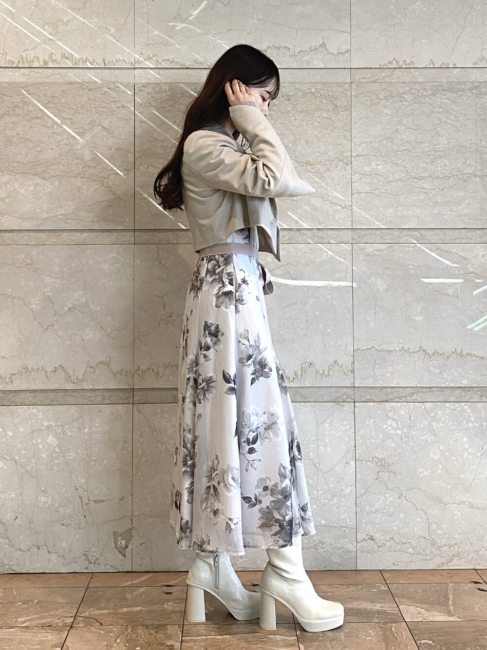 ベージュ系のワンピース、ホワイト系のブーツ、ベージュ系のテーラードジャケットを着用したレディースの秋コーディネートの4枚目の写真