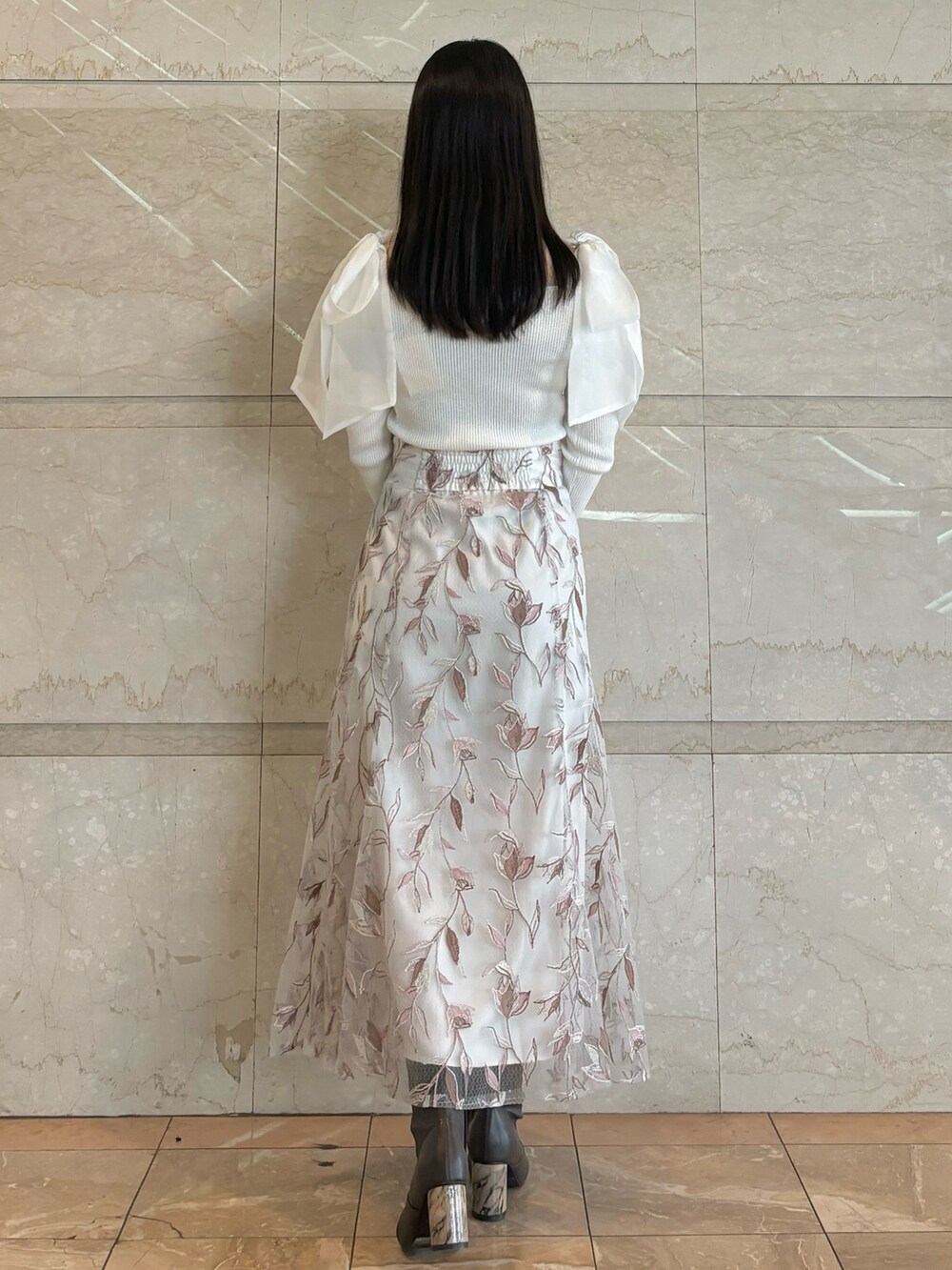 ホワイト系のスカート、ブラウン系のブーツ、ホワイト系のニット/セーターを着用したレディースの秋コーディネートの4枚目の写真