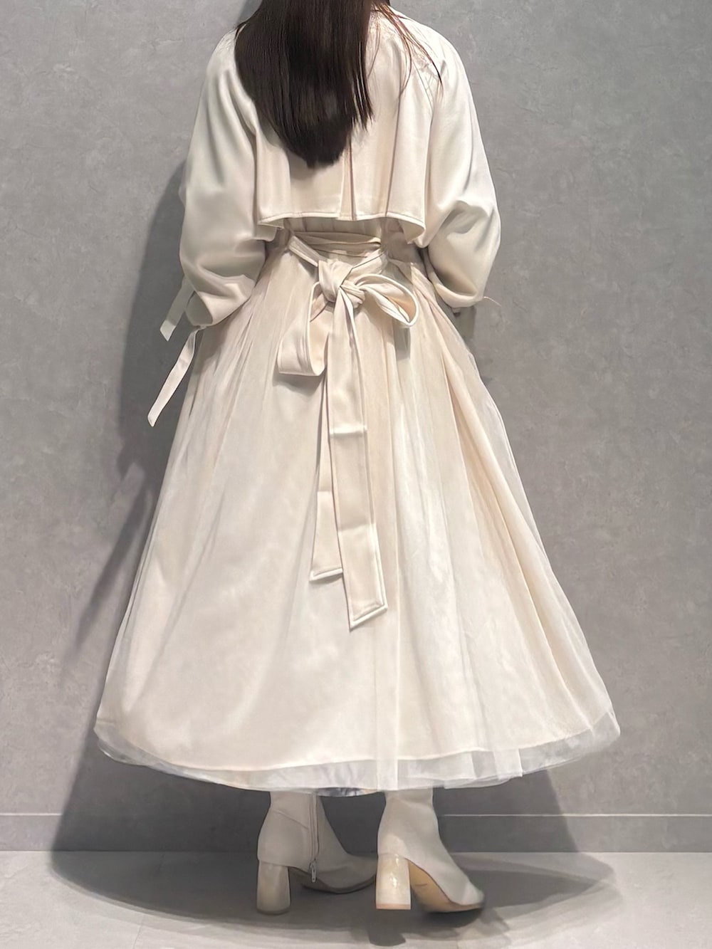 グリーン系のスカート、ホワイト系のブーツ、ブラウン系のニット/セーターを着用したレディースの春コーディネートの6枚目の写真