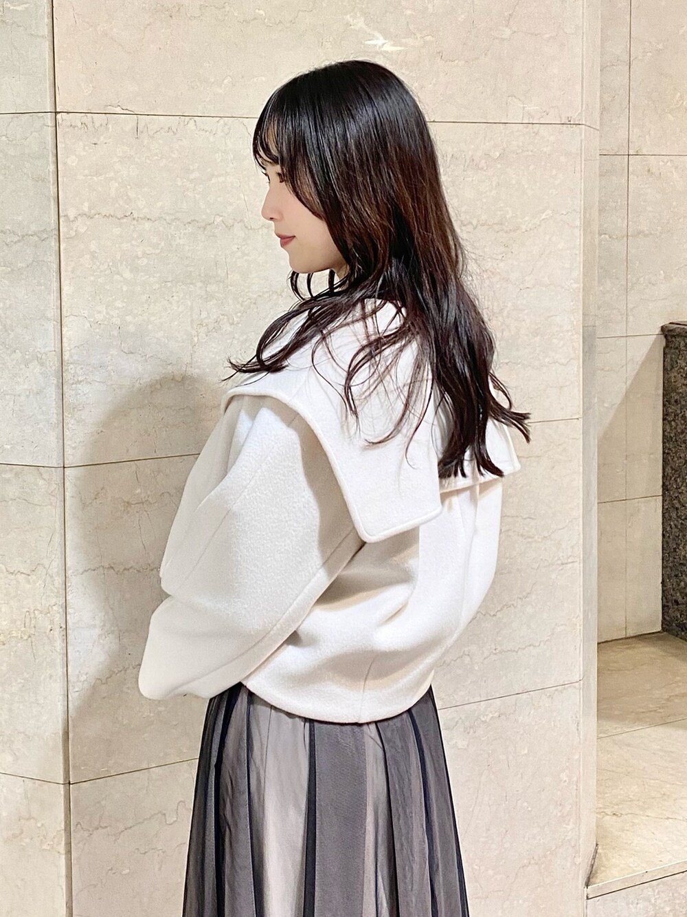 ブラック系のワンピース、ホワイト系のその他アウター、ブラック系のブーツを着用したレディースの秋コーディネートの5枚目の写真