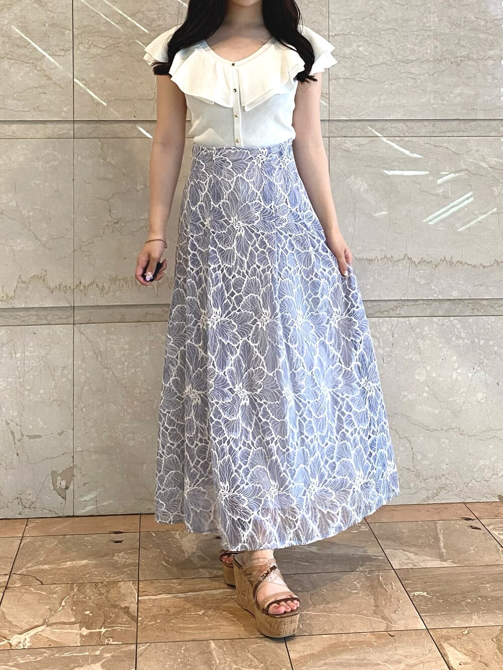 ブルー系のスカート、ホワイト系のニット/セーターを着用したレディースの夏コーディネートの2枚目の写真