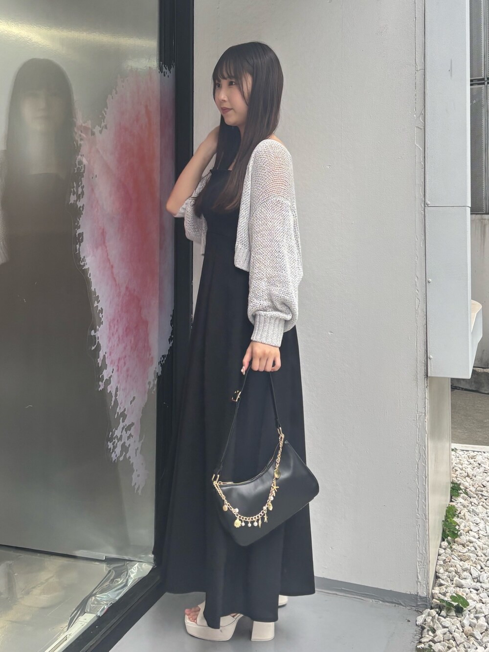 ブラック系のワンピース、ホワイト系のサンダル、ブラック系のハンドバッグを着用したレディースの夏コーディネートの3枚目の写真