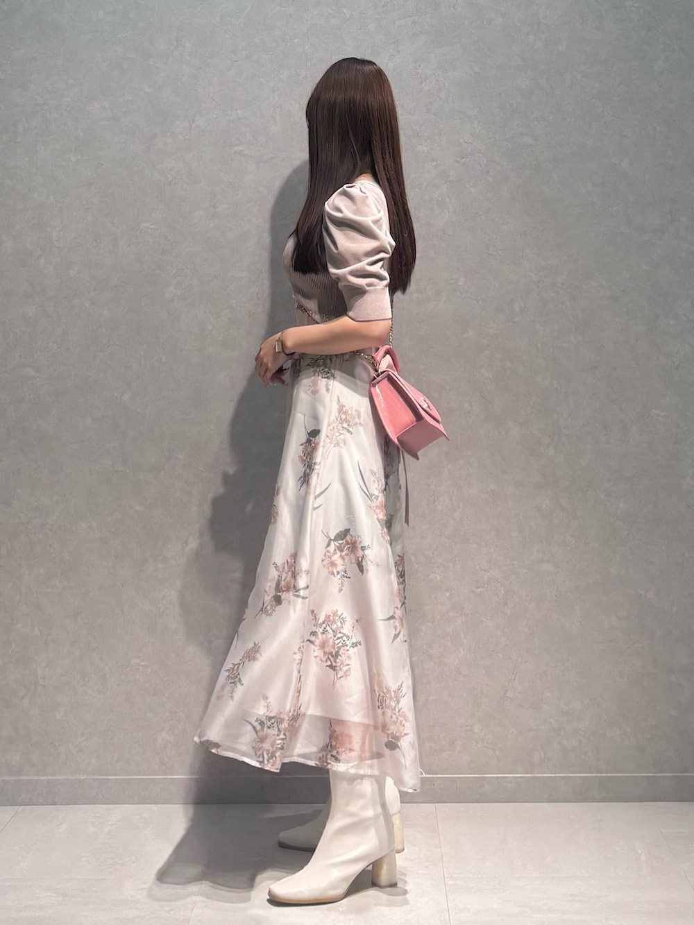 ベージュ系のワンピース、ホワイト系のブーツ、ピンク系のハンドバッグを着用したレディースの冬コーディネートの3枚目の写真