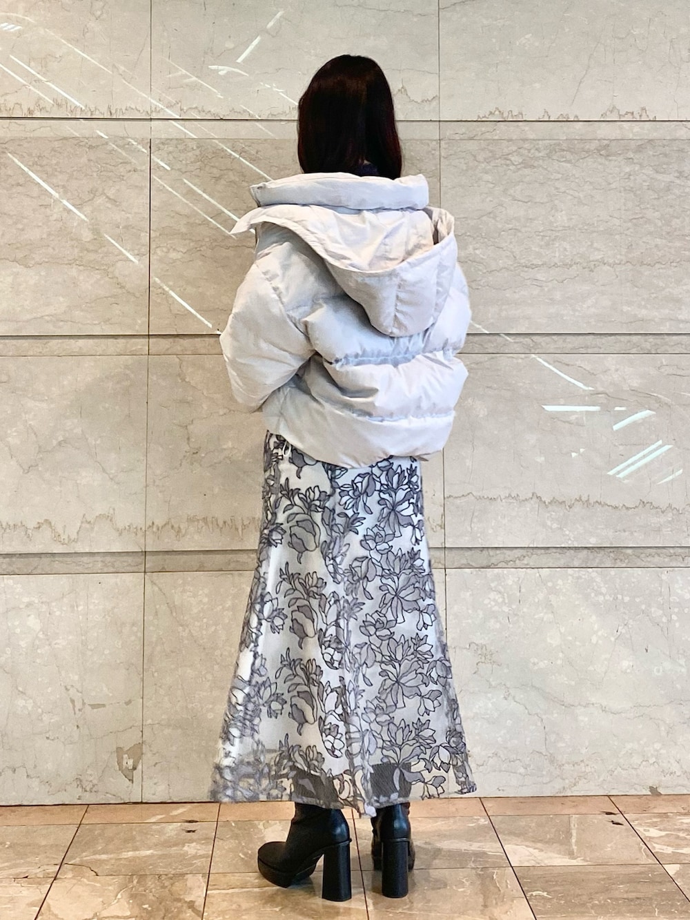 グレー系のスカート、グレー系のダウンジャケット/コート、グレー系のニット/セーターを着用したレディースの冬コーディネートの4枚目の写真