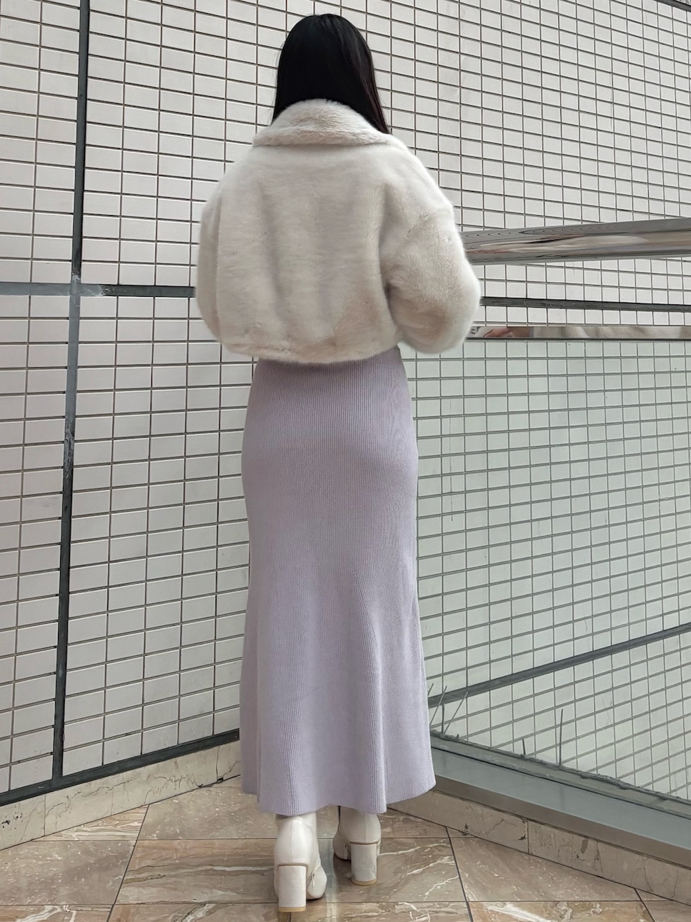 パープル系のワンピース、ホワイト系のブーツ、ホワイト系のその他アウターを着用したレディースの冬コーディネートの3枚目の写真