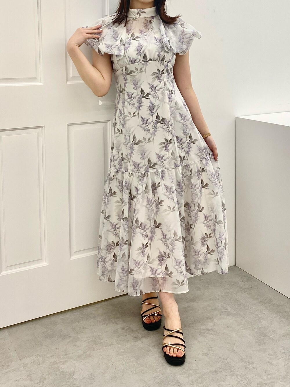 ホワイト系のサンダル、パープル系のワンピースを着用したレディースの春コーディネートの2枚目の写真