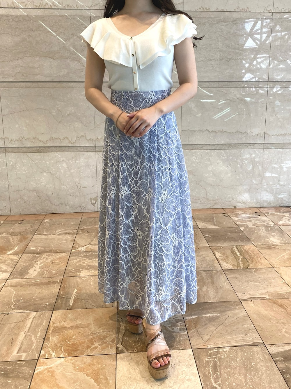 ブルー系のスカート、ホワイト系のニット/セーターを着用したレディースの夏コーディネートの6枚目の写真