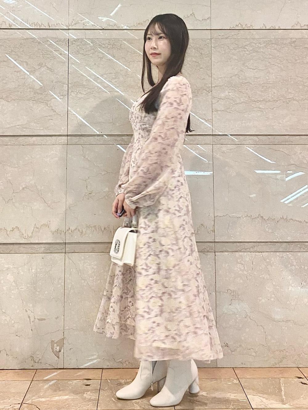 パープル系のワンピース、ホワイト系のブーツ、ホワイト系のショルダーバッグを着用したレディースの冬コーディネートの3枚目の写真