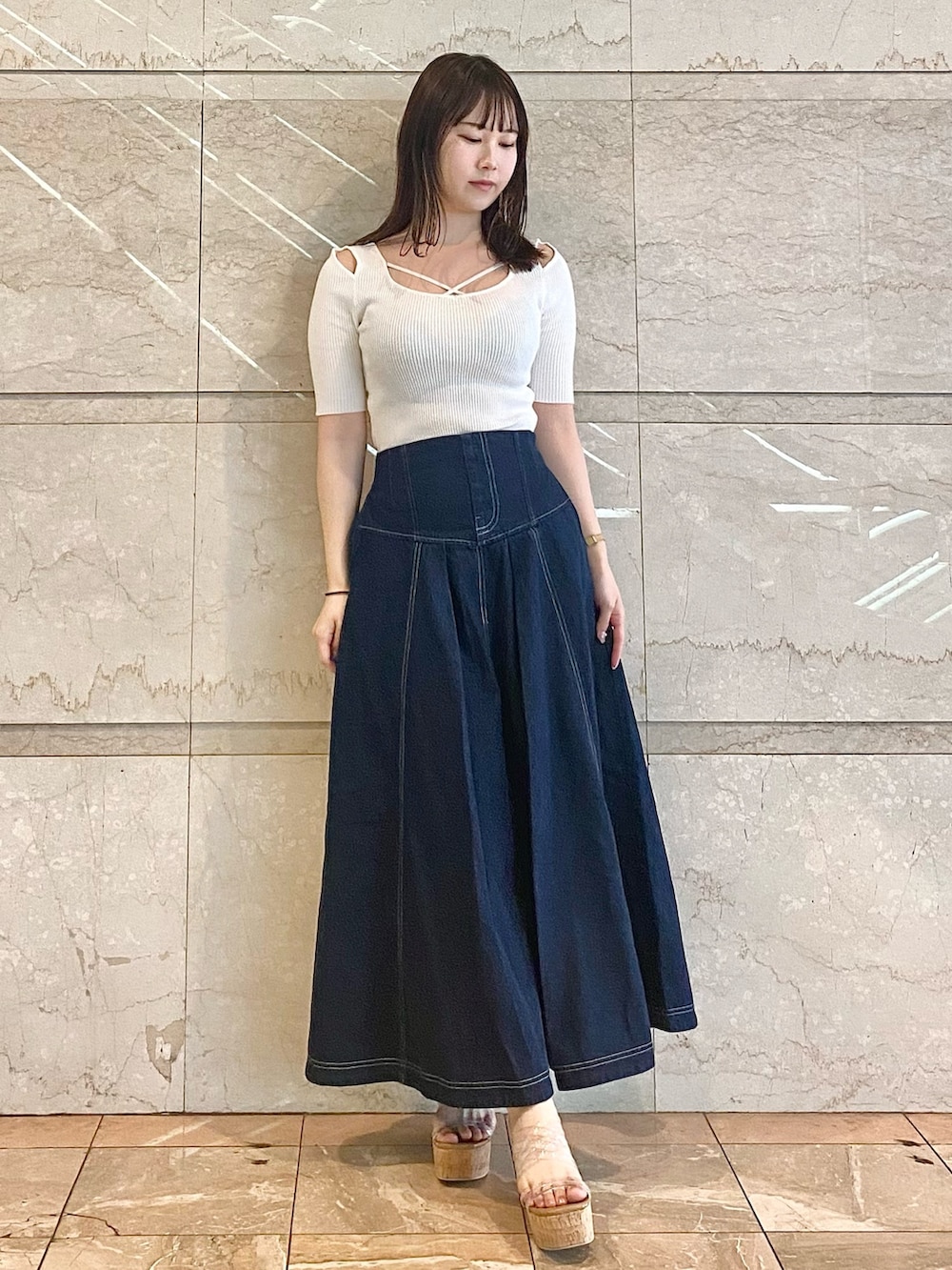 ブルー系のスカート、ホワイト系のニット/セーター、その他のサンダルを着用したレディースの春コーディネートの2枚目の写真