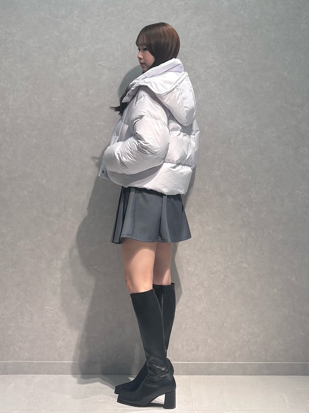 グレー系のスカート、ブラック系のブーツ、グレー系のカーディガン/ボレロを着用したレディースの秋コーディネートの5枚目の写真