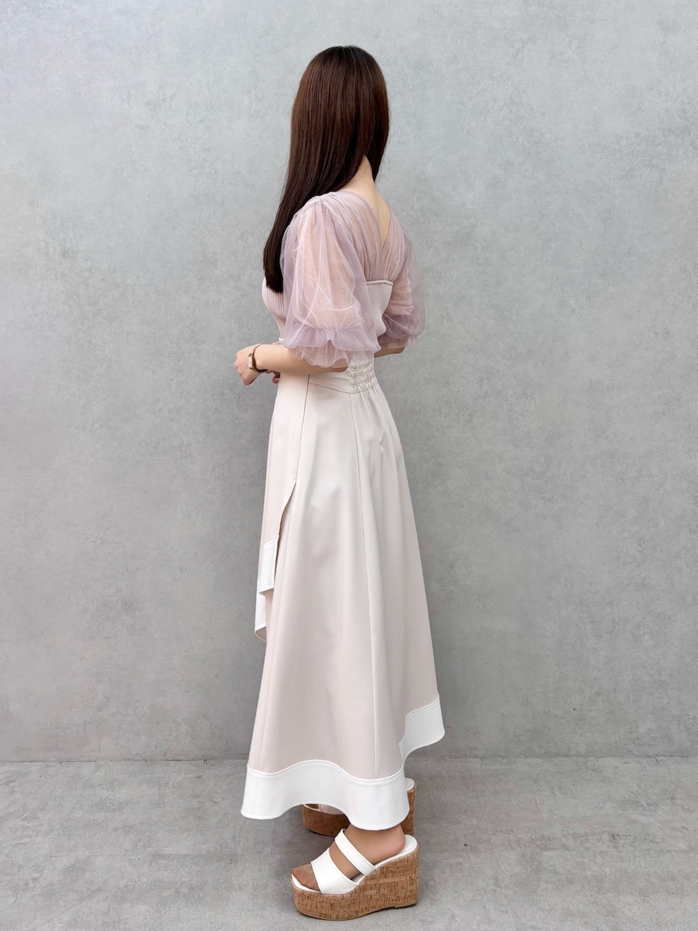 ベージュ系のスカート、ホワイト系のサンダル、ピンク系のニット/セーターを着用したレディースの春コーディネートの3枚目の写真