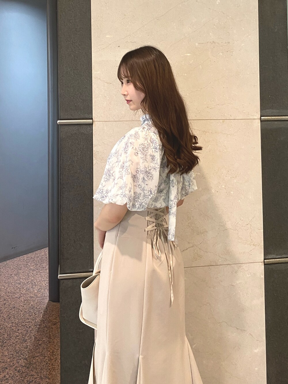 ベージュ系のスカート、ホワイト系のトートバッグ、ブルー系のシャツ/ブラウスを着用したレディースの夏コーディネートの4枚目の写真