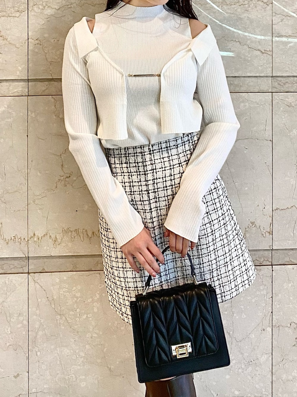 ホワイト系のニット/セーター、ホワイト系のスカート、ブラック系のショルダーバッグを着用したレディースの秋コーディネートの5枚目の写真
