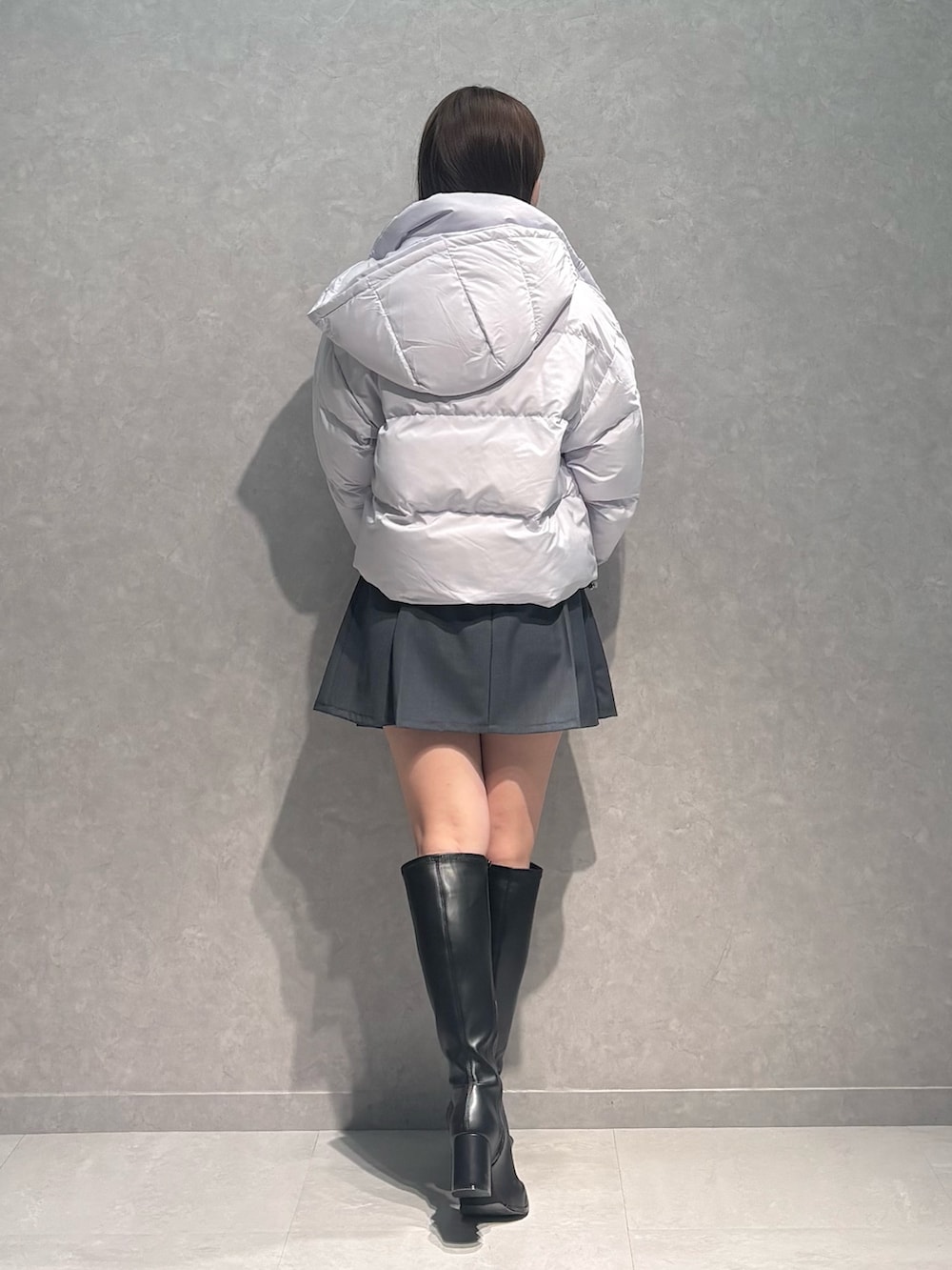 グレー系のスカート、ブラック系のブーツ、グレー系のカーディガン/ボレロを着用したレディースの秋コーディネートの4枚目の写真