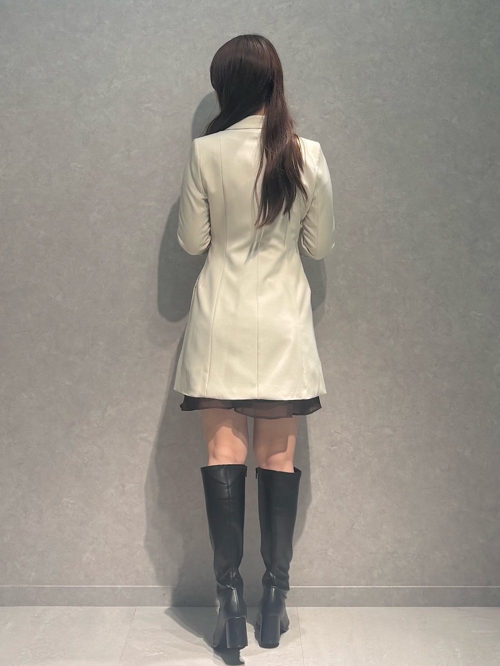 ブラウン系のワンピース、ホワイト系のワンピース、ブラック系のブーツを着用したレディースの秋コーディネートの3枚目の写真