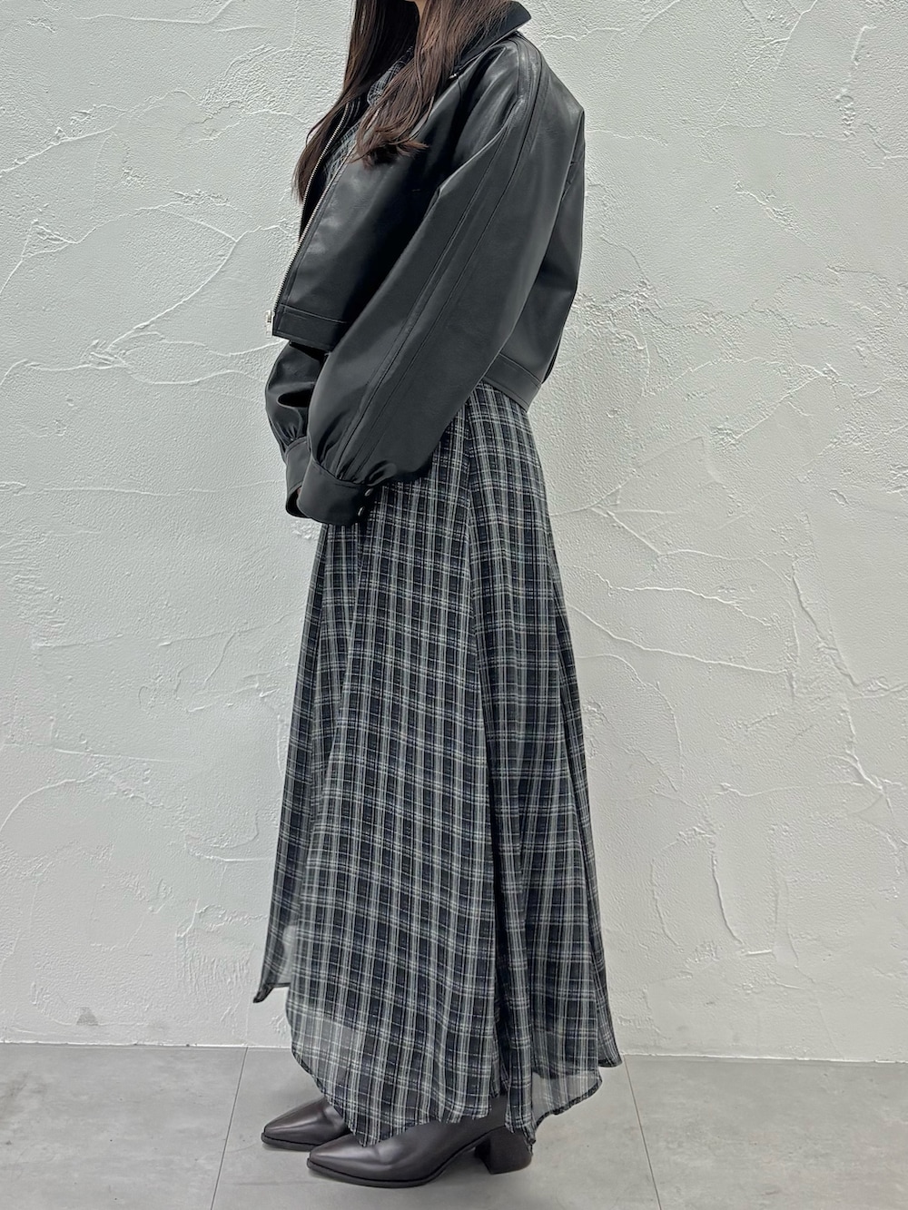 ブラック系のワンピース、ブラウン系のブーツ、ブラック系のブルゾンを着用したレディースの秋コーディネートの2枚目の写真