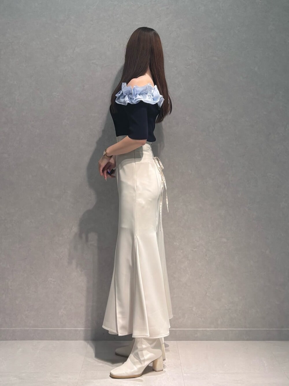 ホワイト系のブーツ、ホワイト系のスカート、ブルー系のニット/セーターを着用したレディースの春コーディネートの5枚目の写真