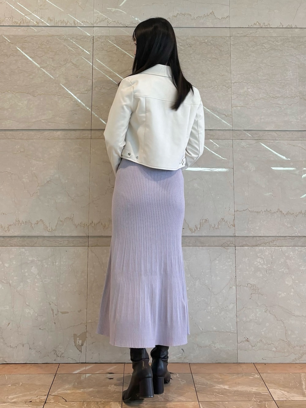 パープル系のワンピース、ホワイト系のライダースジャケット、ブラウン系のブーツを着用したレディースの秋コーディネートの3枚目の写真