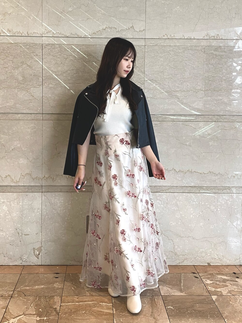 ピンク系のスカート、ホワイト系のブーツ、ホワイト系のニット/セーターを着用したレディースの夏コーディネートの3枚目の写真