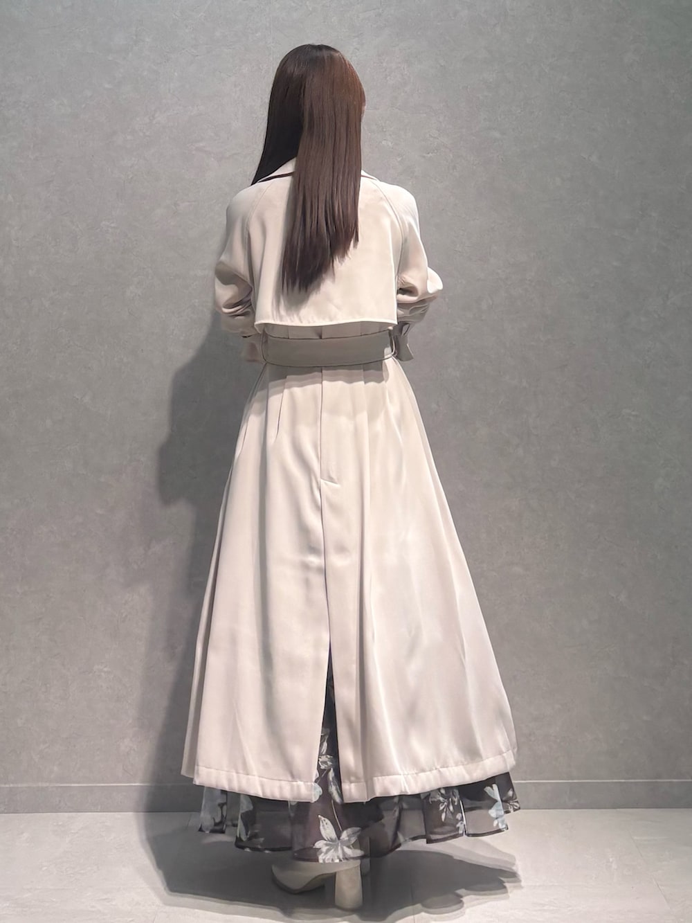 ブラウン系のスカート、ホワイト系のニット/セーター、ホワイト系のトレンチコートを着用したレディースの春コーディネートの4枚目の写真