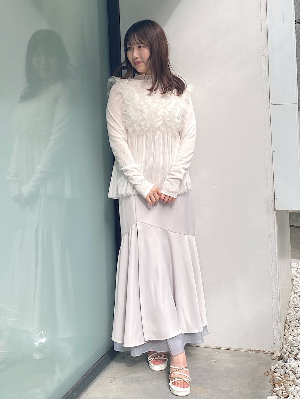 グレー系のスカート、ホワイト系のサンダル、ホワイト系のシャツ/ブラウスを着用したレディースの夏コーディネートの2枚目の写真