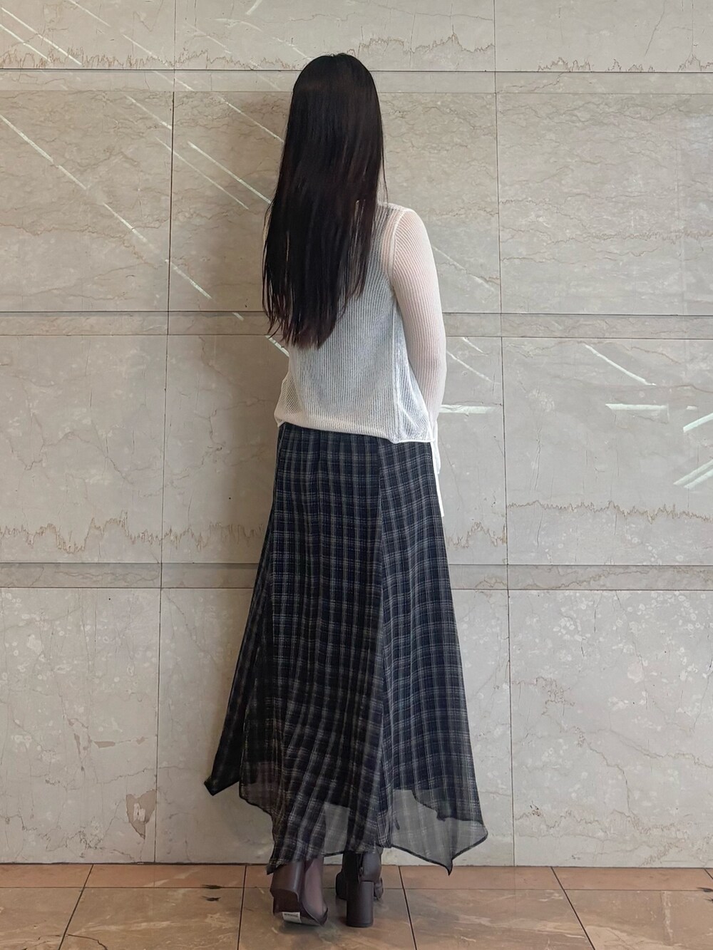 ブラック系のワンピース、ホワイト系のカーディガン/ボレロ、ブラウン系のブーツを着用したレディースの夏コーディネートの4枚目の写真