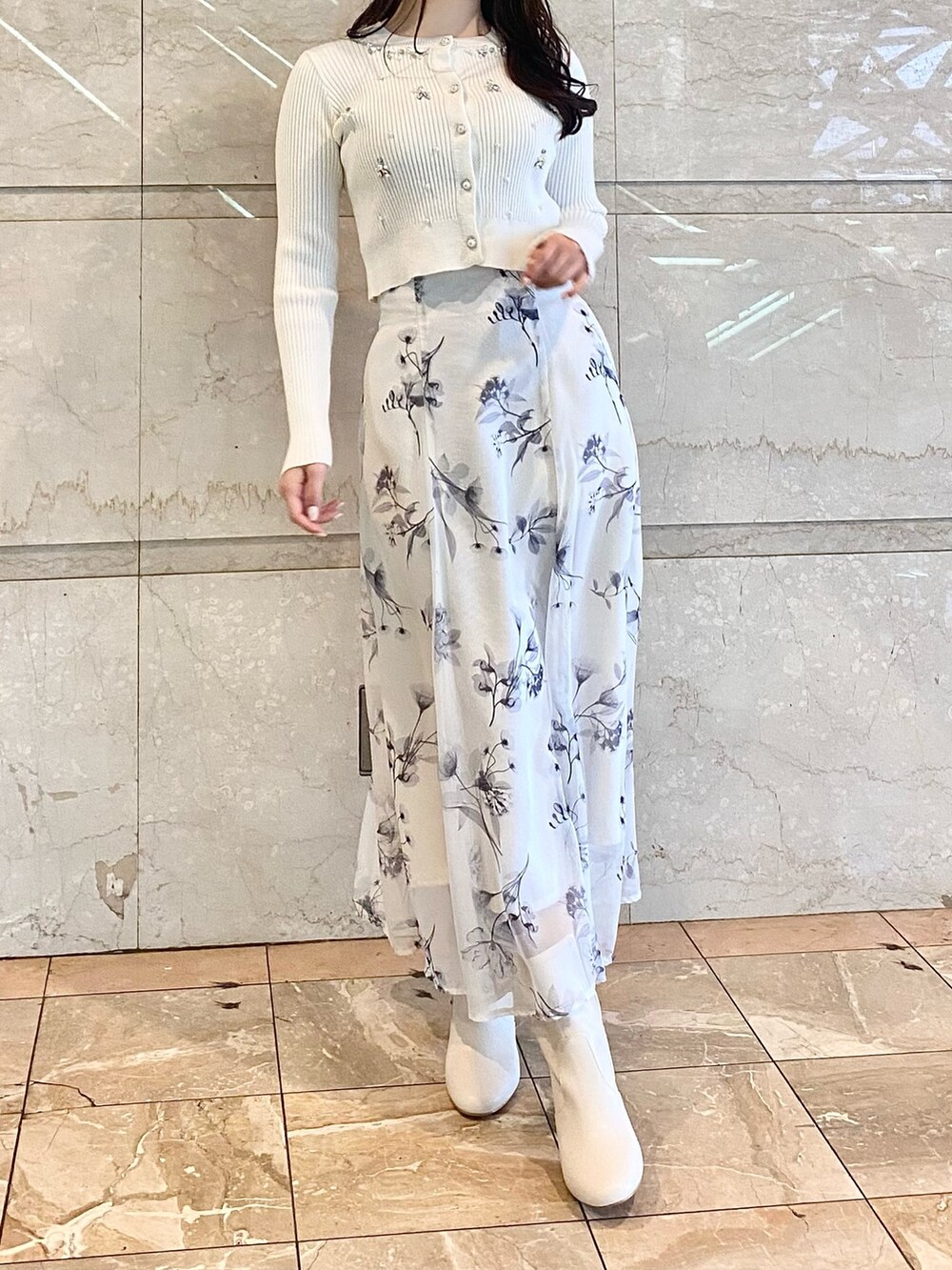 ホワイト系のスカート、ホワイト系のカーディガン/ボレロ、ホワイト系のブーツを着用したレディースの冬コーディネートの2枚目の写真