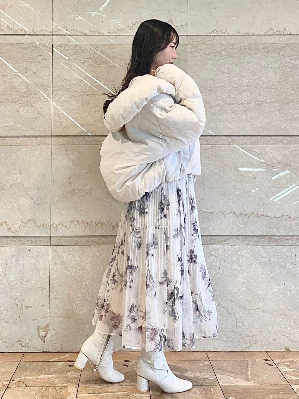 ピンク系のワンピース、ホワイト系のダウンジャケット/コート、ホワイト系のブーツを着用したレディースの冬コーディネートの4枚目の写真