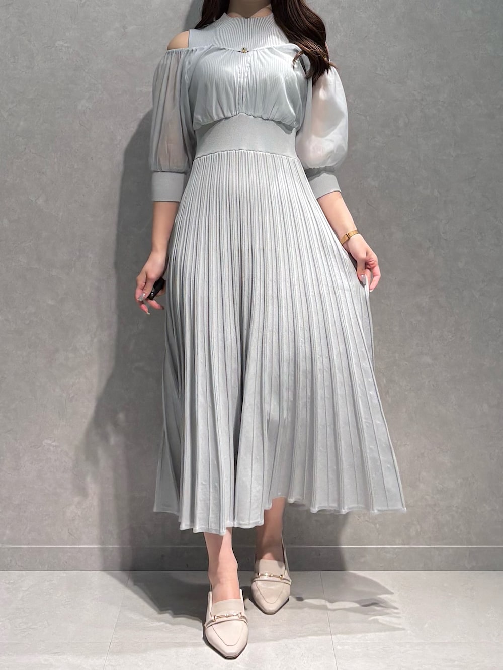 グレー系のワンピース、ホワイト系のテーラードジャケット、ホワイト系のパンプスを着用したレディースの春コーディネートの3枚目の写真