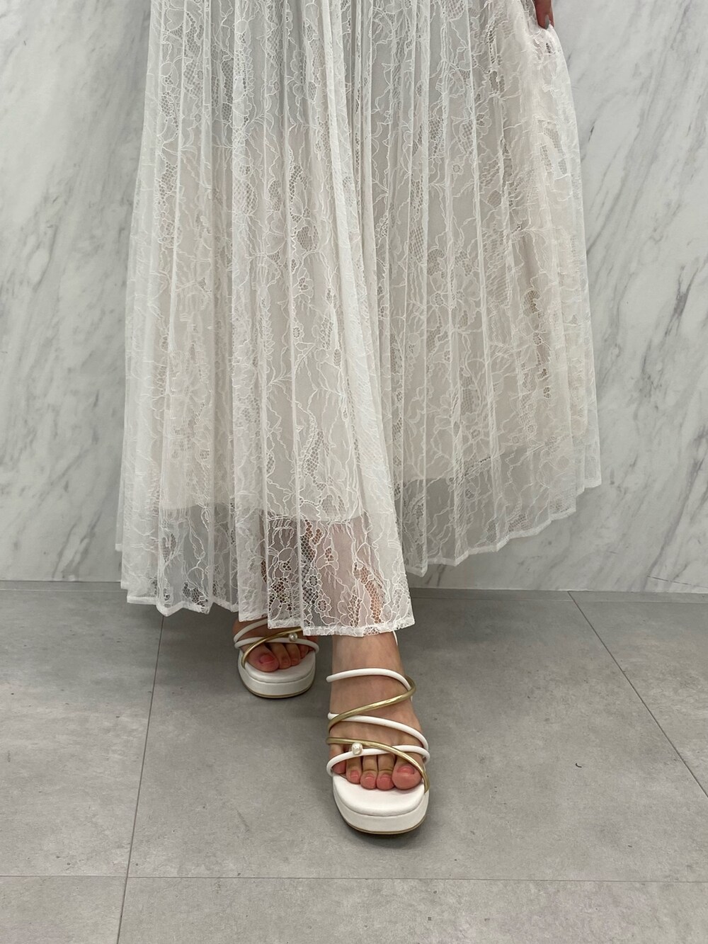 ベージュ系のショルダーバッグ、ホワイト系のサンダル、ホワイト系のシャツ/ブラウスを着用したレディースの夏コーディネートの5枚目の写真