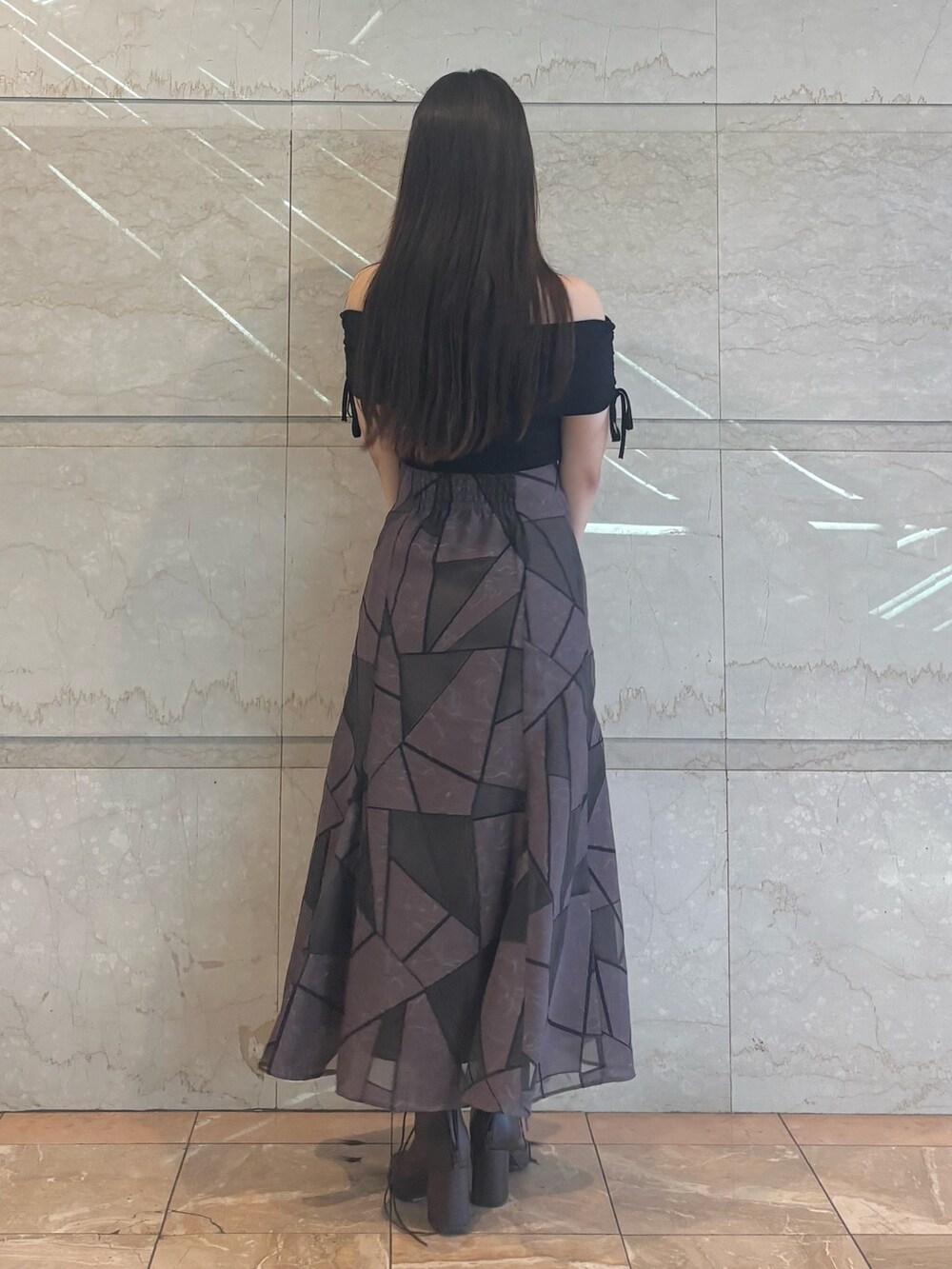 ブラウン系のブーツ、ブラウン系のスカート、ブラック系のニット/セーターを着用したレディースの夏コーディネートの4枚目の写真