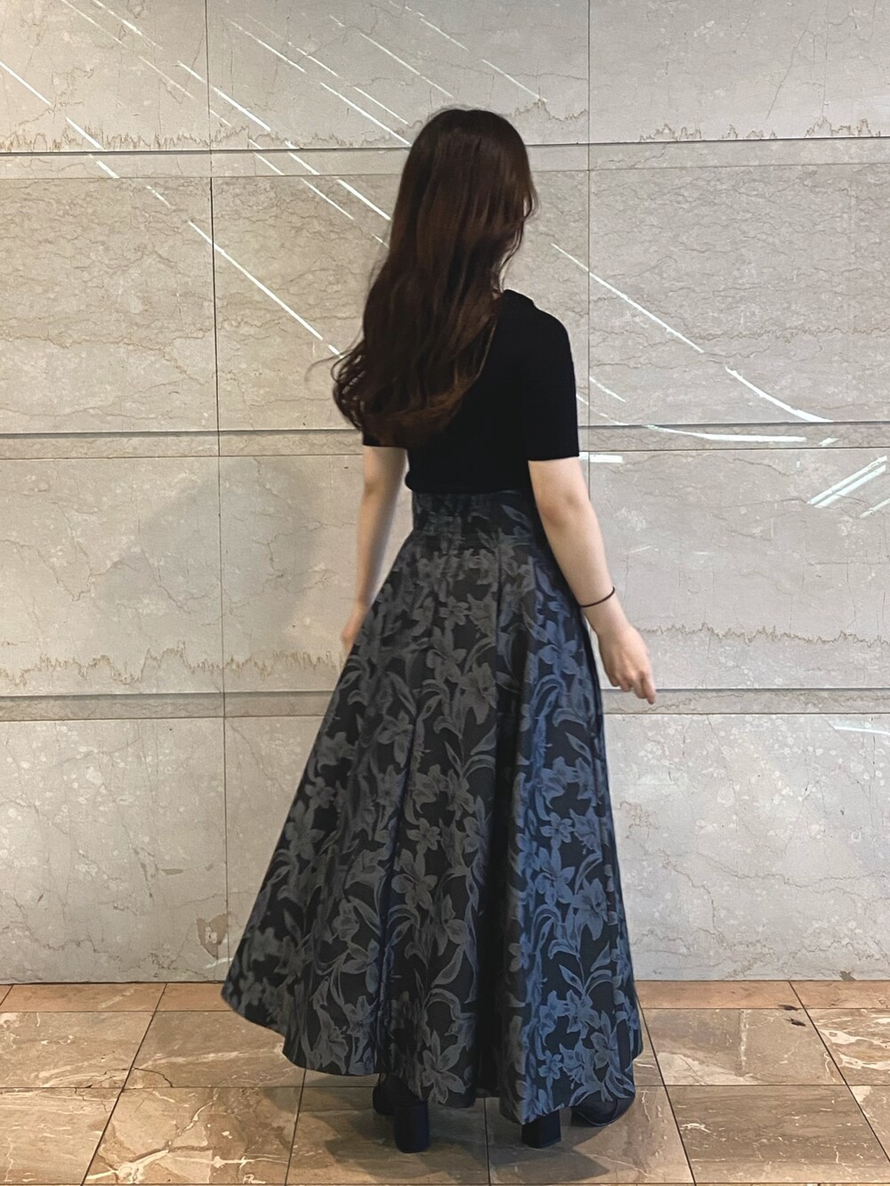 グレー系のスカート、ブラック系のブーツ、ホワイト系のニット/セーターを着用したレディースの秋コーディネートの4枚目の写真