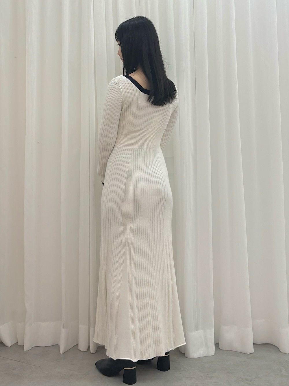 ホワイト系のワンピース、ブラック系のブーツを着用したレディースの秋コーディネートの2枚目の写真