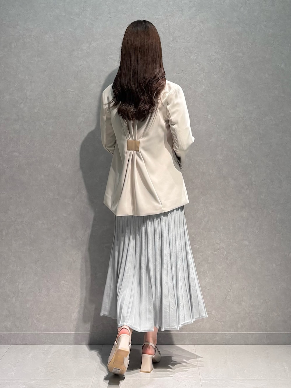 グレー系のワンピース、ホワイト系のテーラードジャケット、ホワイト系のパンプスを着用したレディースの春コーディネートの5枚目の写真