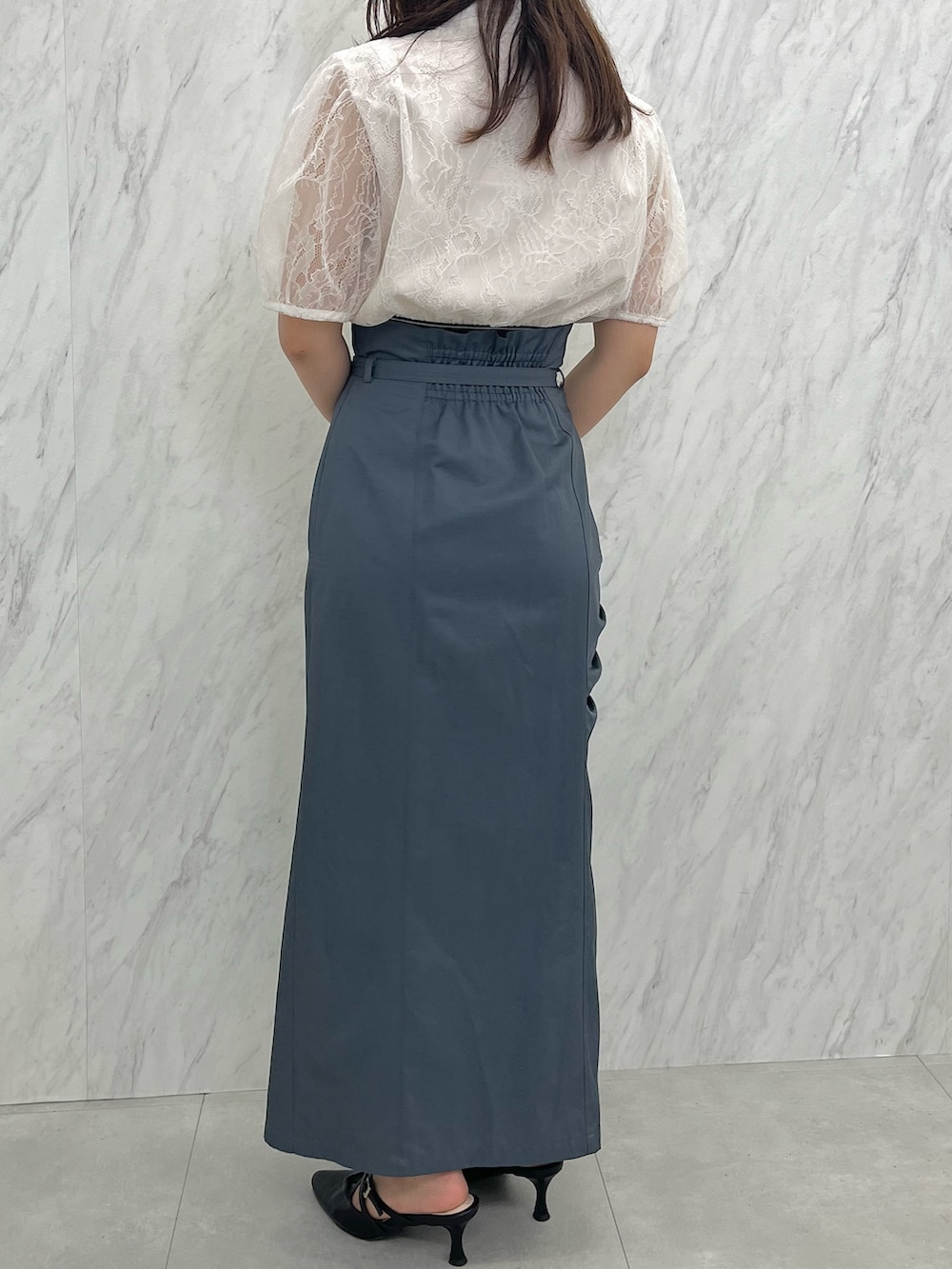 グレー系のスカート、ホワイト系のシャツ/ブラウス、ブラック系のパンプスを着用したレディースの夏コーディネートの2枚目の写真