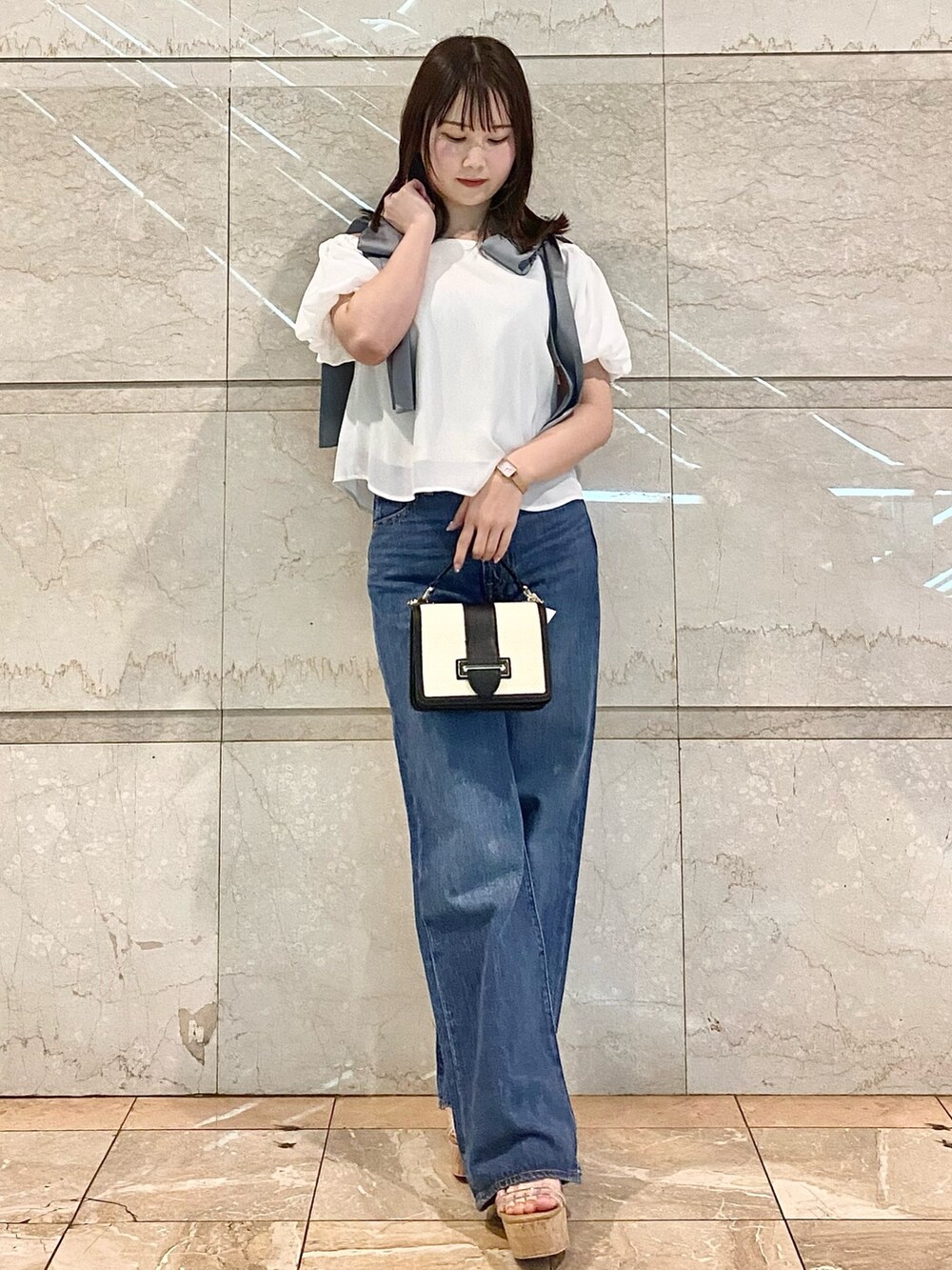 ホワイト系のシャツ/ブラウス、ブルー系のデニムパンツ、その他のサンダルを着用したレディースの春コーディネートの2枚目の写真