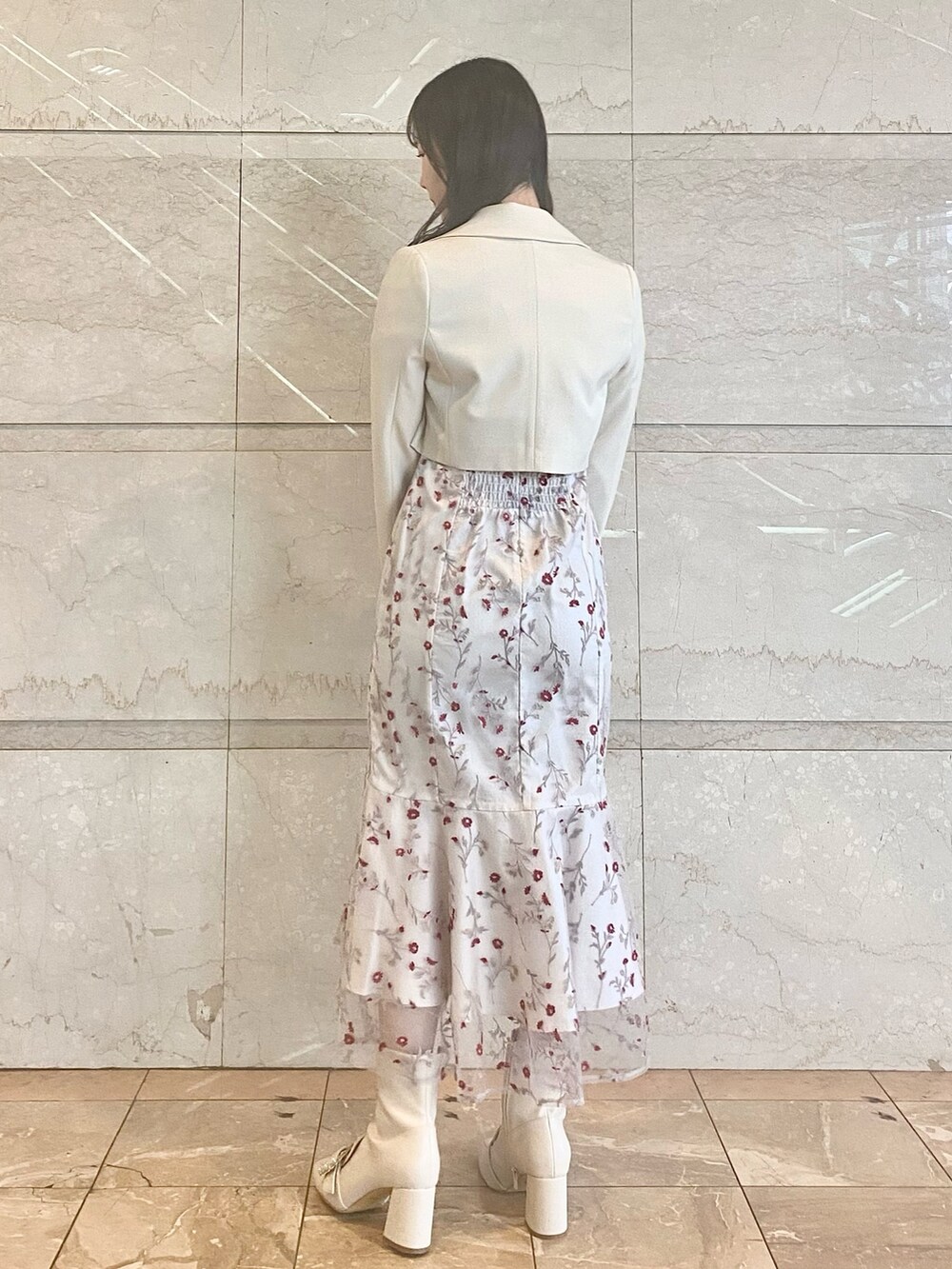 レッド系のワンピース、ホワイト系のブーツ、ホワイト系のテーラードジャケットを着用したレディースの春コーディネートの5枚目の写真