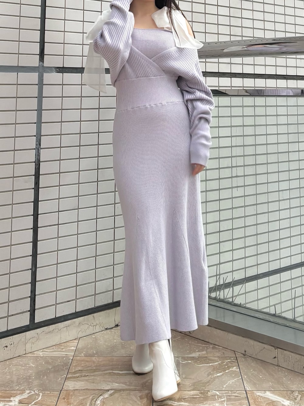 パープル系のワンピース、ホワイト系のブーツを着用したレディースの冬コーディネートの2枚目の写真