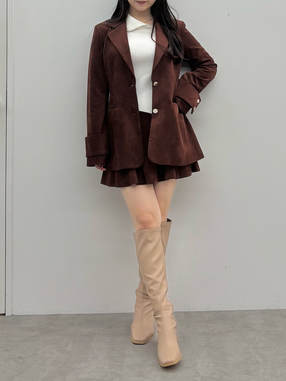 ホワイト系のニット/セーター、ブラウン系のテーラードジャケット、ブラウン系のスカートを着用したレディースの秋コーディネートの2枚目の写真