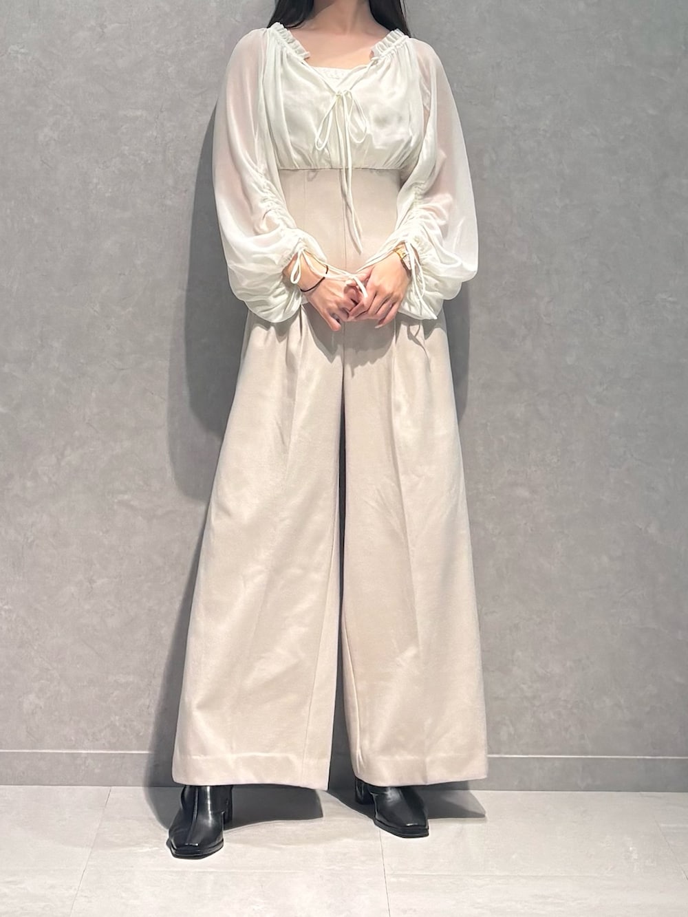 ホワイト系のワンピース、ブラック系のブーツを着用したレディースの秋コーディネートの3枚目の写真