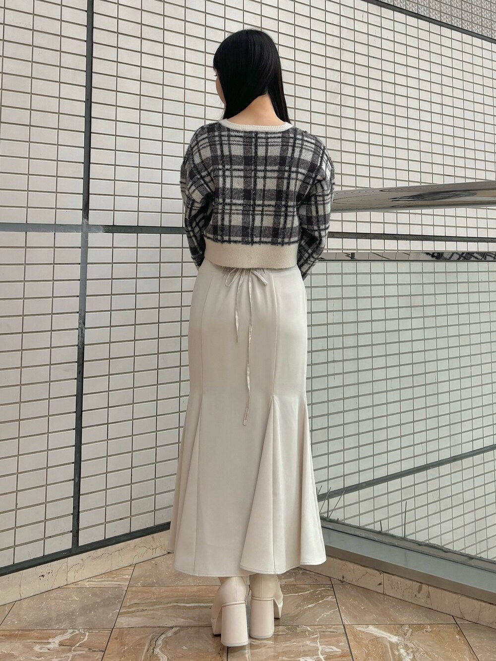 ホワイト系のスカート、ホワイト系のブーツ、ホワイト系のカーディガン/ボレロを着用したレディースの秋コーディネートの2枚目の写真