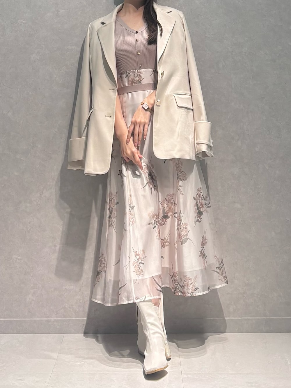 ベージュ系のワンピース、ホワイト系のテーラードジャケット、ホワイト系のブーツを着用したレディースの春コーディネートの2枚目の写真