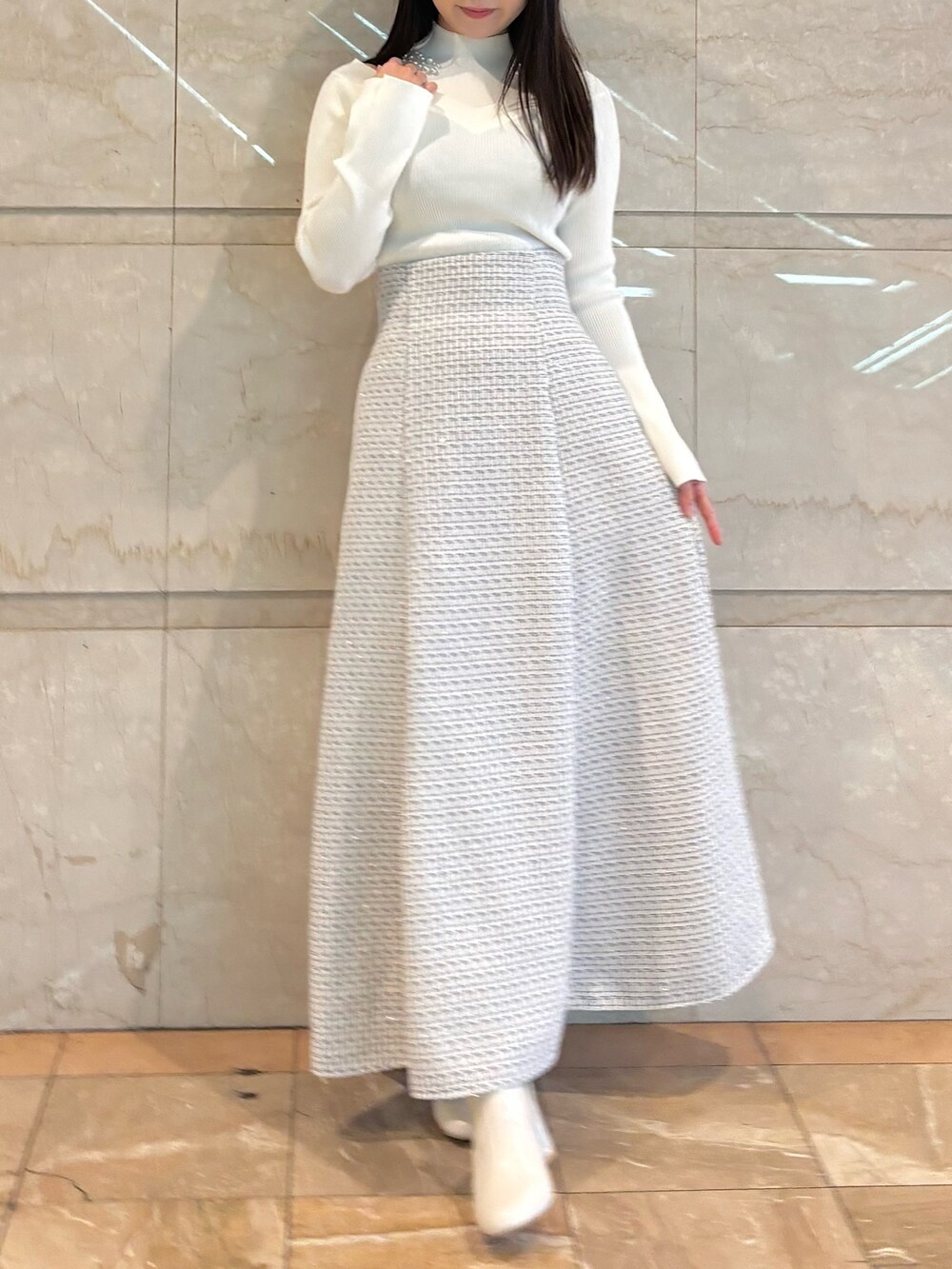 ホワイト系のスカート、ホワイト系のブーツ、ホワイト系のニット/セーターを着用したレディースの冬コーディネートの4枚目の写真