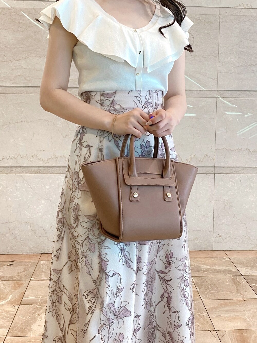 ピンク系のスカート、ホワイト系のニット/セーター、ブラウン系のトートバッグを着用したレディースの夏コーディネートの5枚目の写真