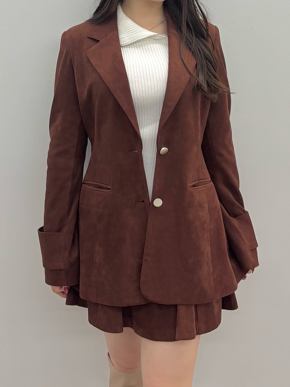 ホワイト系のニット/セーター、ブラウン系のテーラードジャケット、ブラウン系のスカートを着用したレディースの秋コーディネートの5枚目の写真